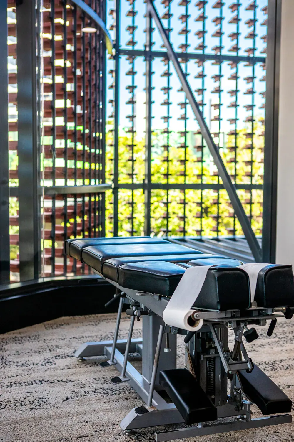 Chiropractic adjusting table at Vitalign, beside the brick screen and vertical garden at The Eaves, West Village
